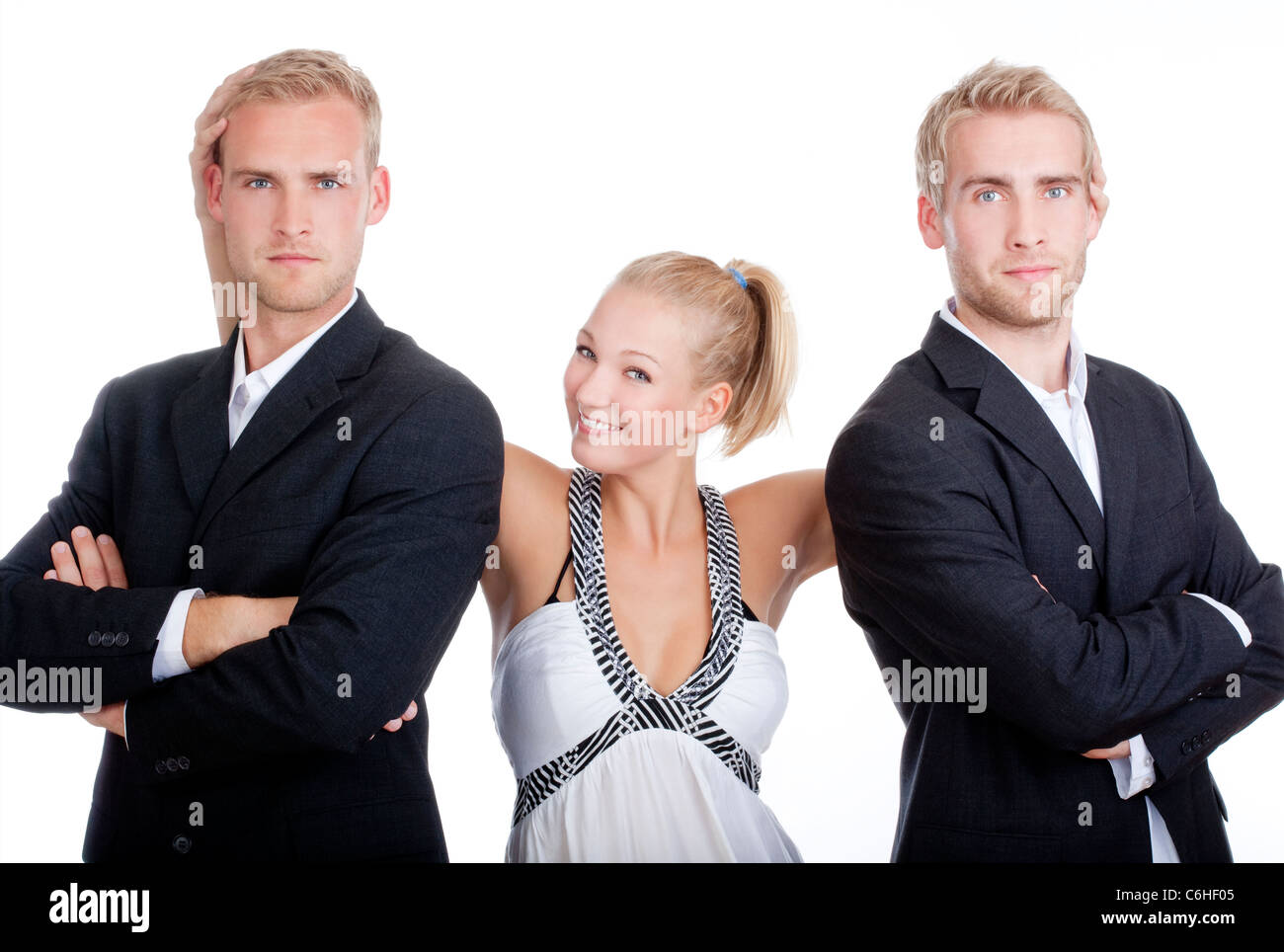 junge Frau im Kleid steht zwischen zwei Männern in Anzügen - isoliert auf weiss Stockfoto