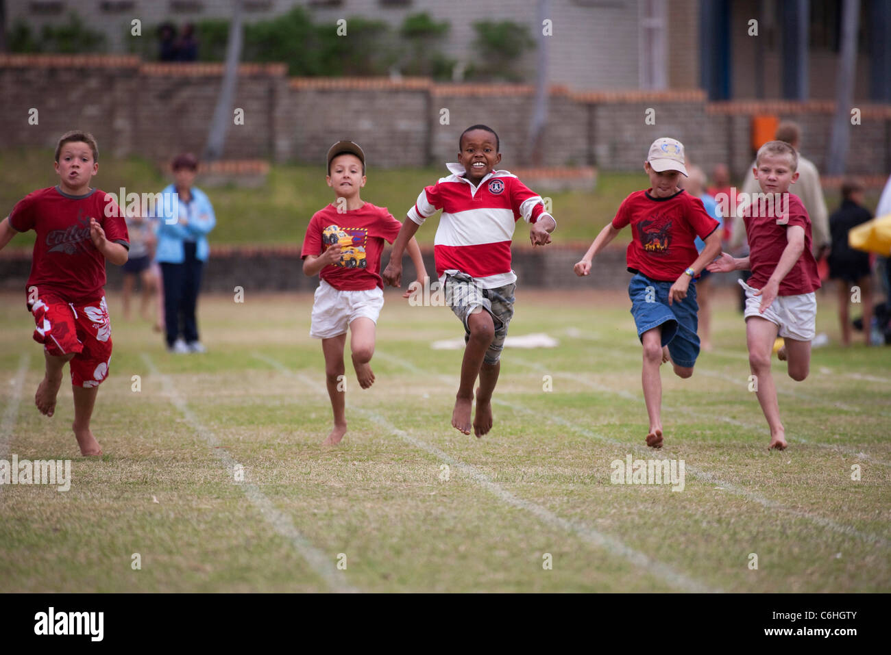 Kinder im Grundschulalter zwischen-Haus Leichtathletik Rennen einfahren Stockfoto