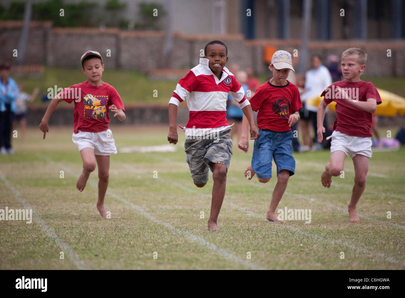 Kinder im Grundschulalter zwischen-Haus Leichtathletik Rennen einfahren Stockfoto