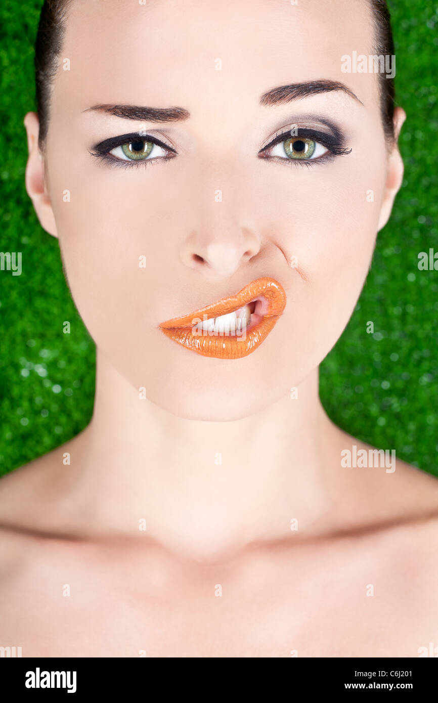 Closeup Mode Porträt einer Frau, die ein seltsames Gesicht isoliert auf grün ziehen Stockfoto