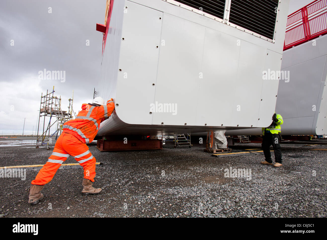 Arbeiter zu bewegen eine Wind-Turbine-Gondel in Mostyn Docks, Wales Stockfoto