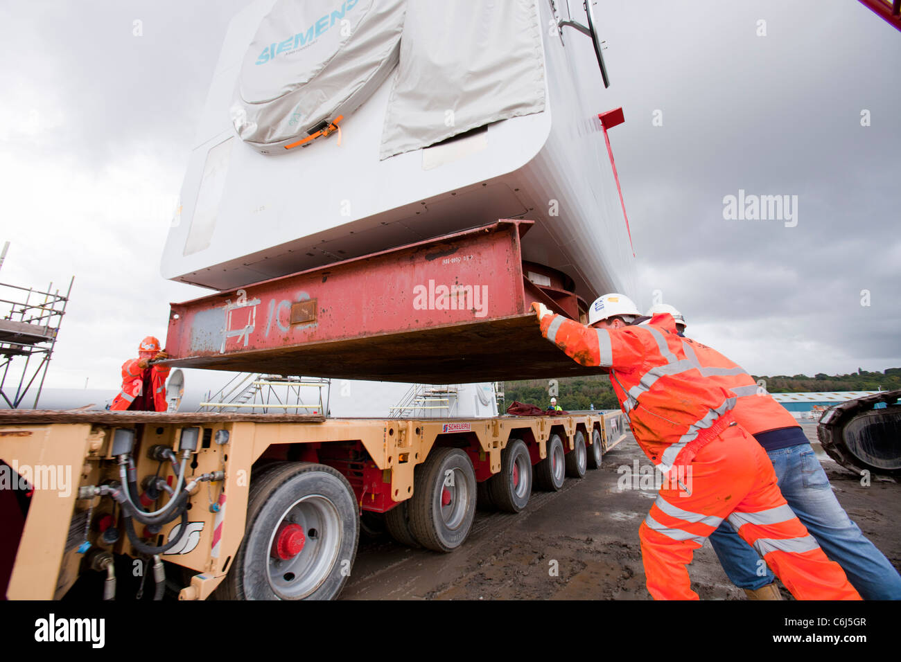 Arbeiter zu bewegen eine Wind-Turbine-Gondel in Mostyn Docks, Wales Stockfoto