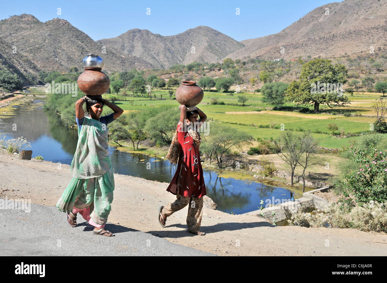 Zwei Dorffrauen Wasserkrüge auf tragen den Kopf Aravalli Hills Rajasthan Indien Stockfoto