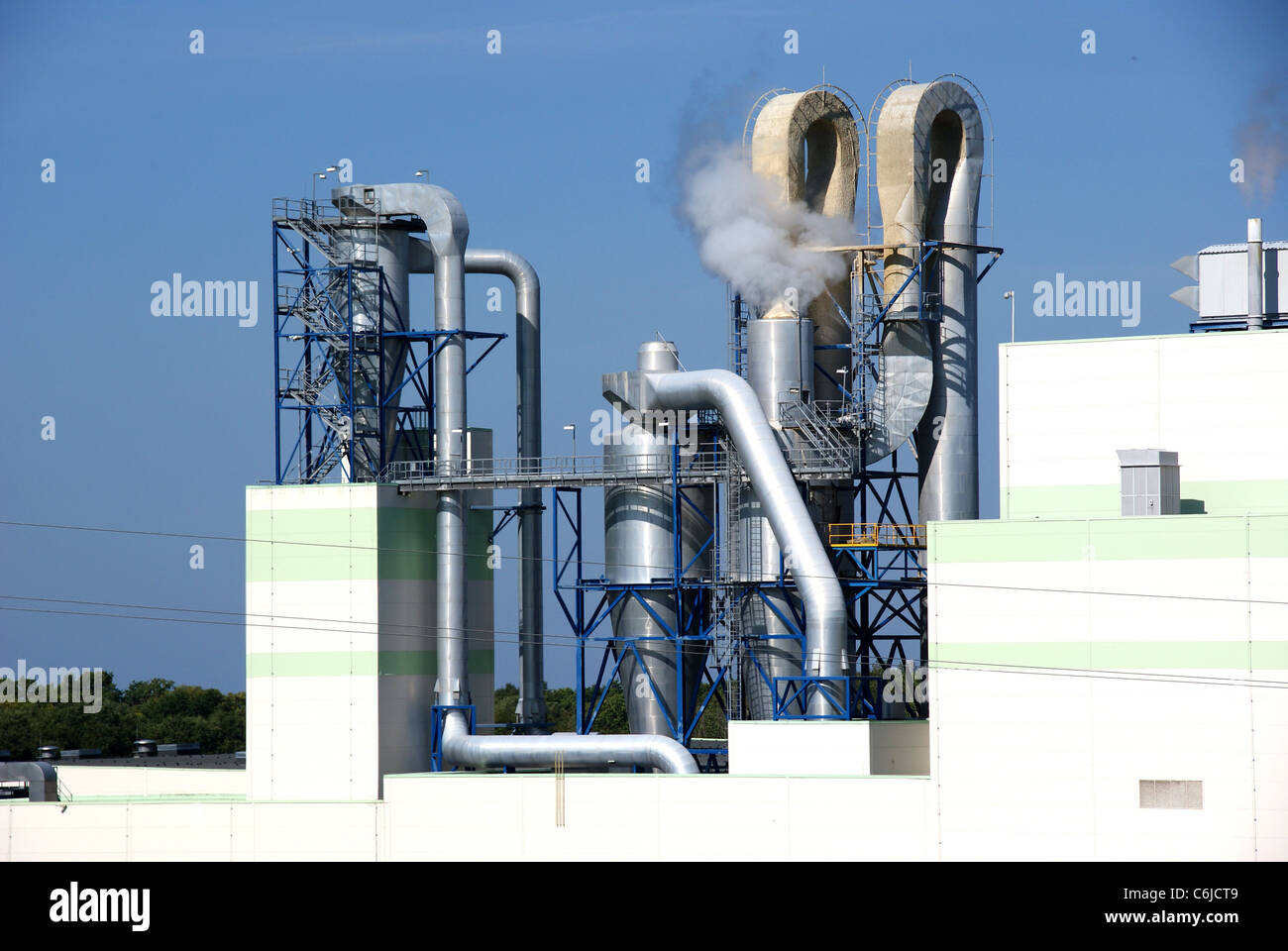 Rohre einer Fabrik auf einem Hintergrund des blauen Himmels Stockfoto