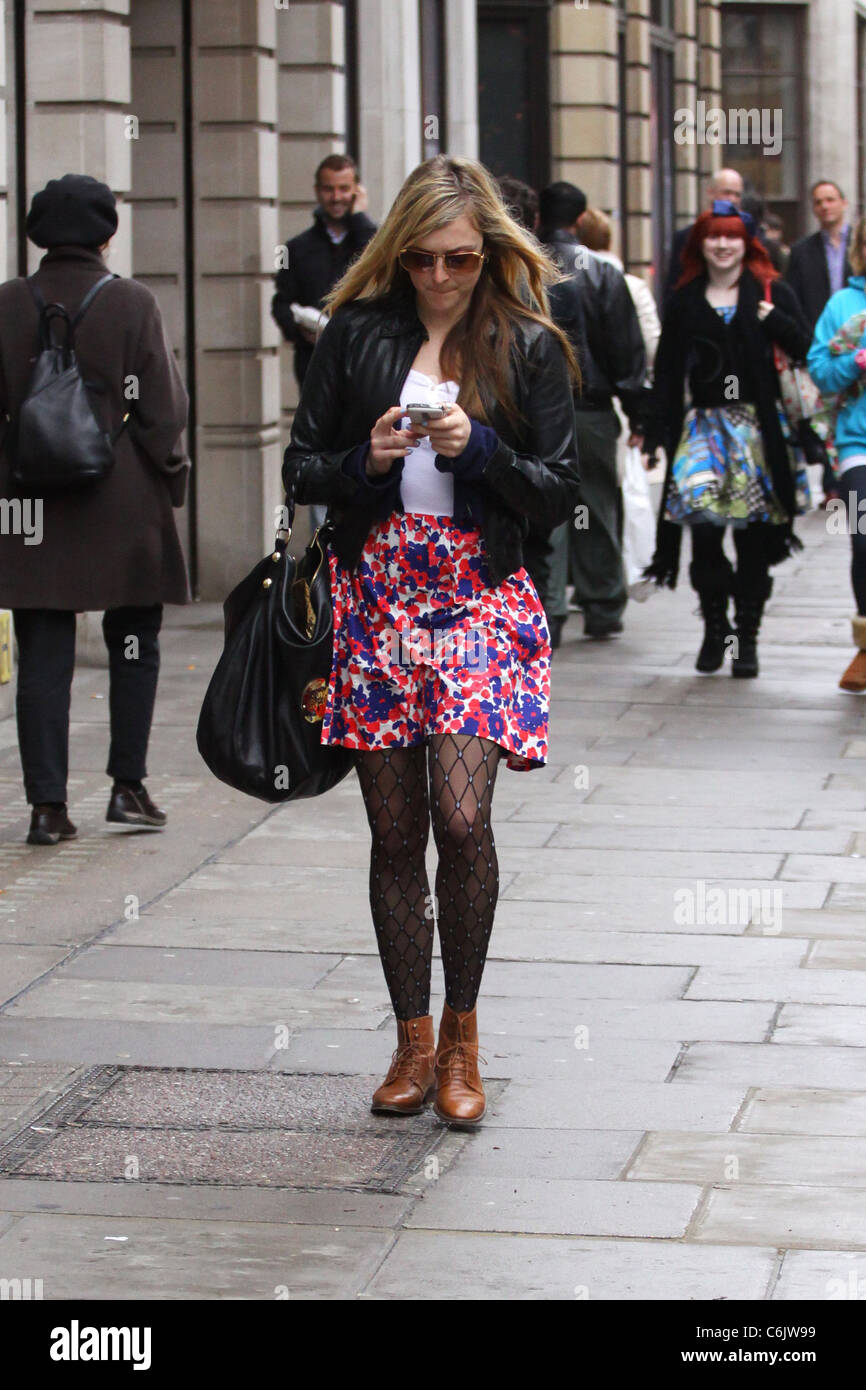 Fearne Cotton Texte auf ihrem Handy als She Spaziergänge auf der Straße. London, England - 19.03.10 Stockfoto