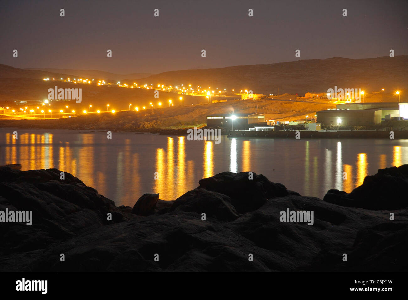 Lüderitz-Hafen-Lichter in der Nacht im Wasser gespiegelt. Stockfoto