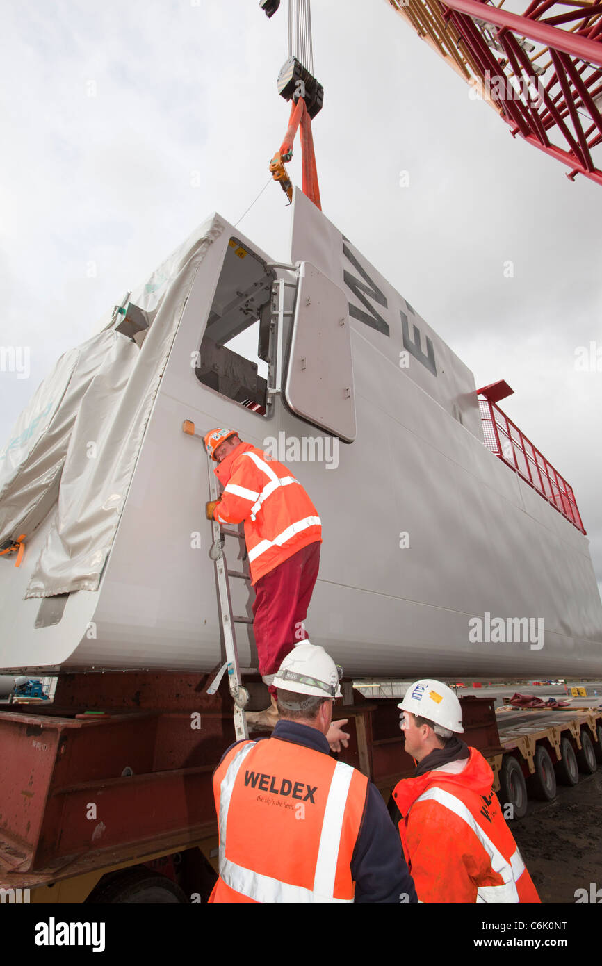 Arbeiter zu bewegen eine Wind-Turbine-Gondel in Mostyn Docks, Wales Stockfoto