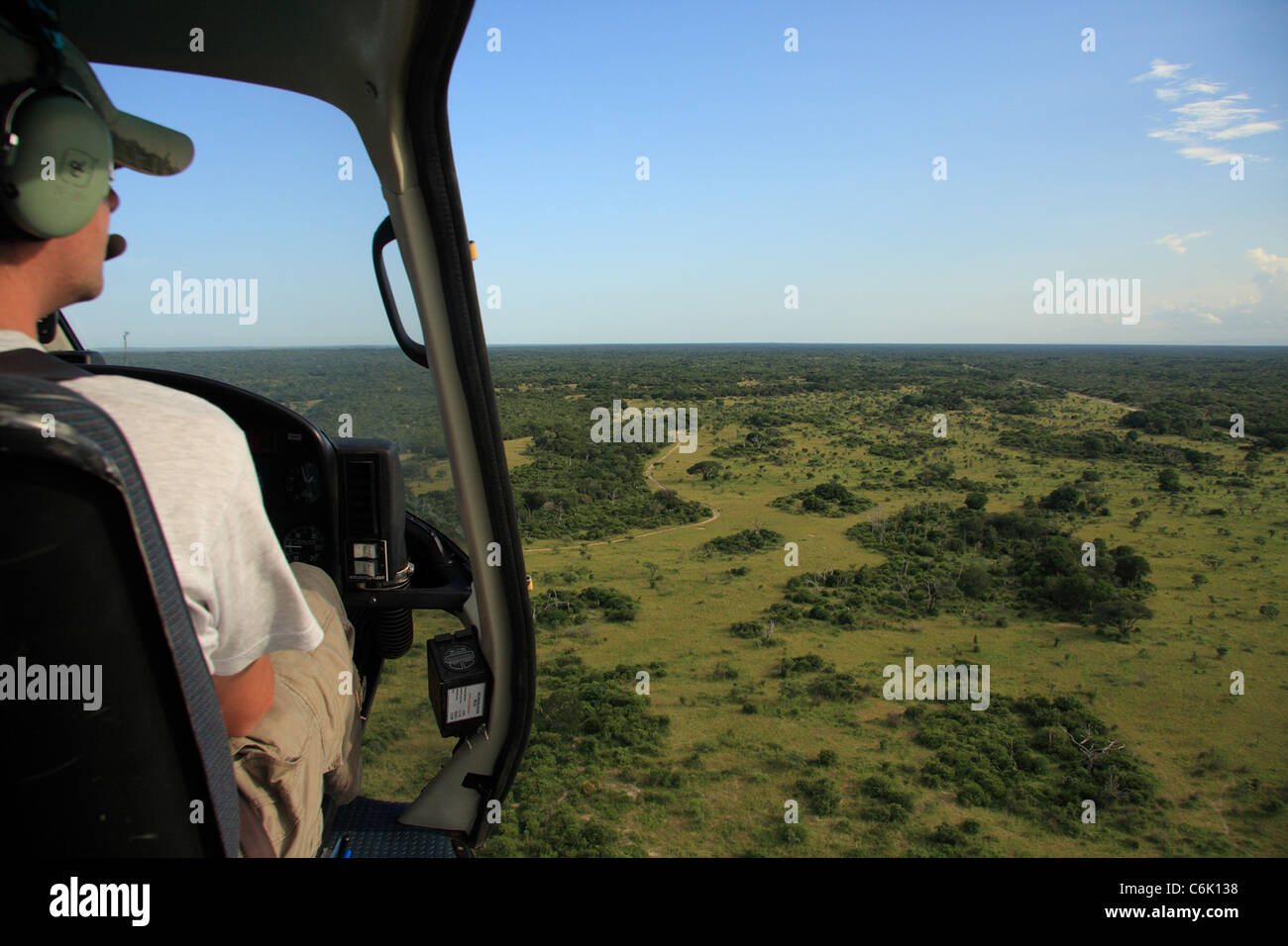 Hubschrauber-Pilot mit Blick über weite Küstenebenen Stockfoto