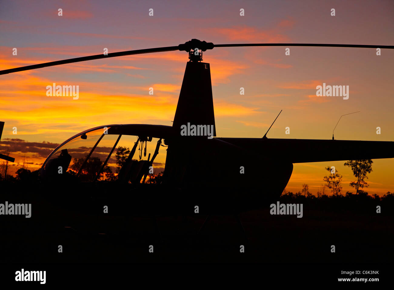 Robinson R44 Hubschrauber bei Sonnenuntergang, Jabiru Flughafen East, Kakadu-Nationalpark, Northern Territory, Australien Stockfoto