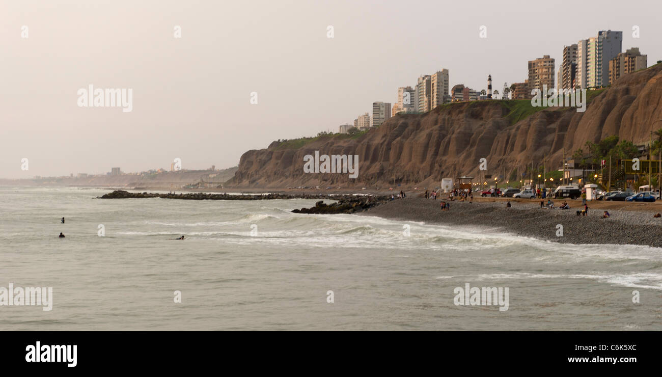 Touristen am Strand mit einer Stadt im Hintergrund, Miraflores District, Provinz Lima, Peru Stockfoto