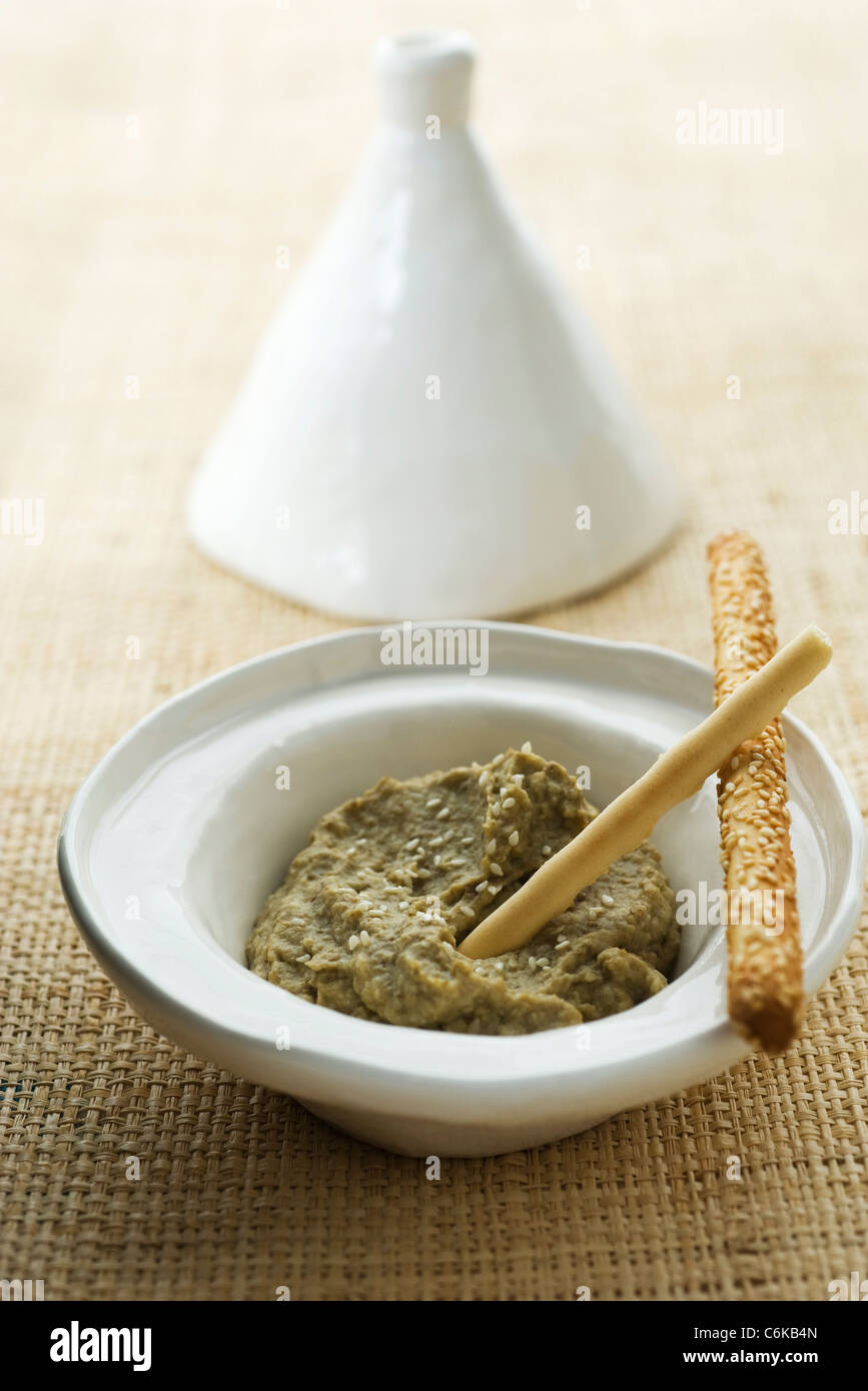 Geröstete Auberginen Dip serviert in Tajine-Gericht mit Grissini Stockfoto