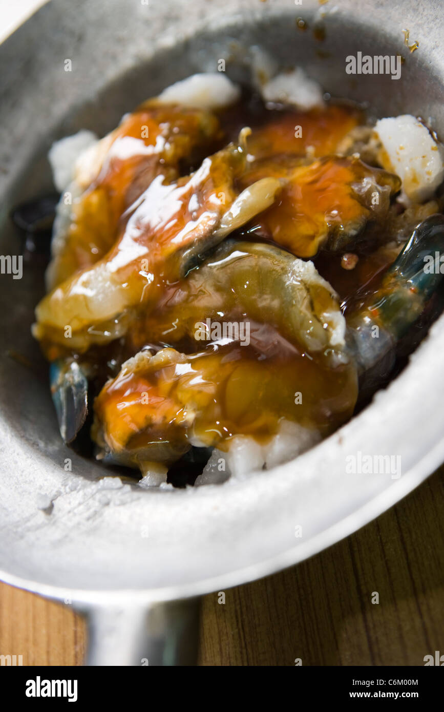 Garnelen in Pfanne beträufelt mit Kokosöl und Schweinefleisch Lager Stockfoto