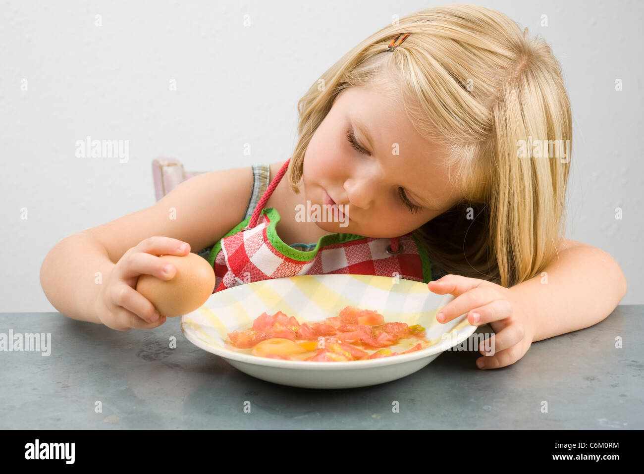 Kleines Mädchen knacken Ei Stockfoto