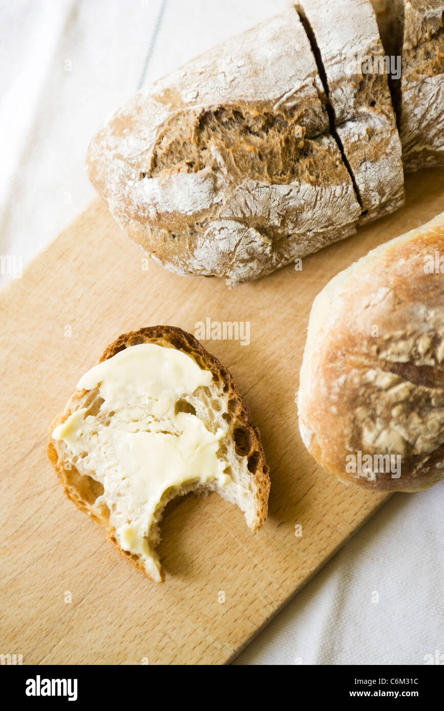 Frisches Brot, gebutterte Scheibe mit fehlenden Biss Stockfoto