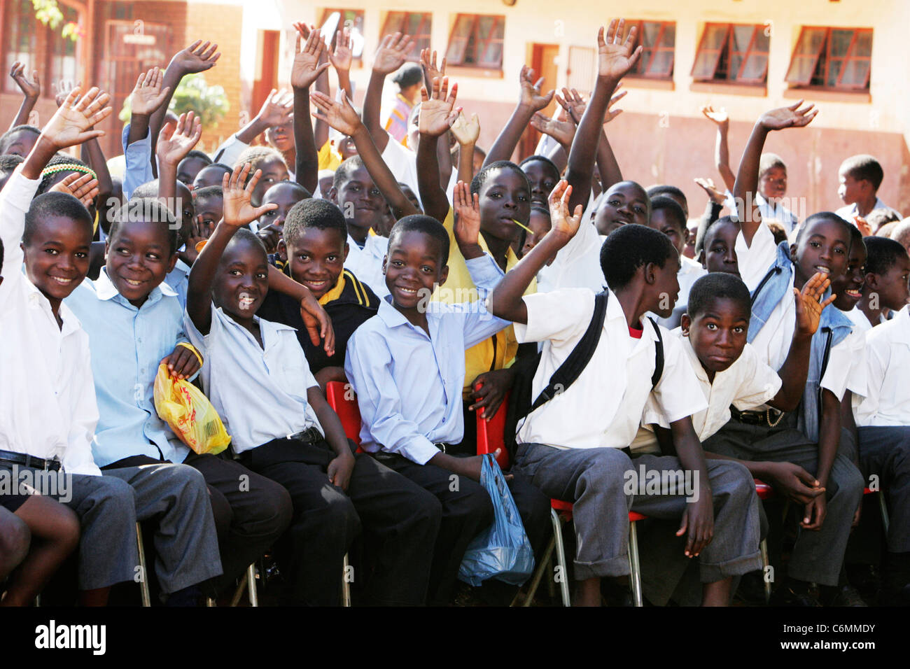 Gruppe lächelnder junge Schuljungen in ein Outdoor-Klassenzimmer winken Stockfoto