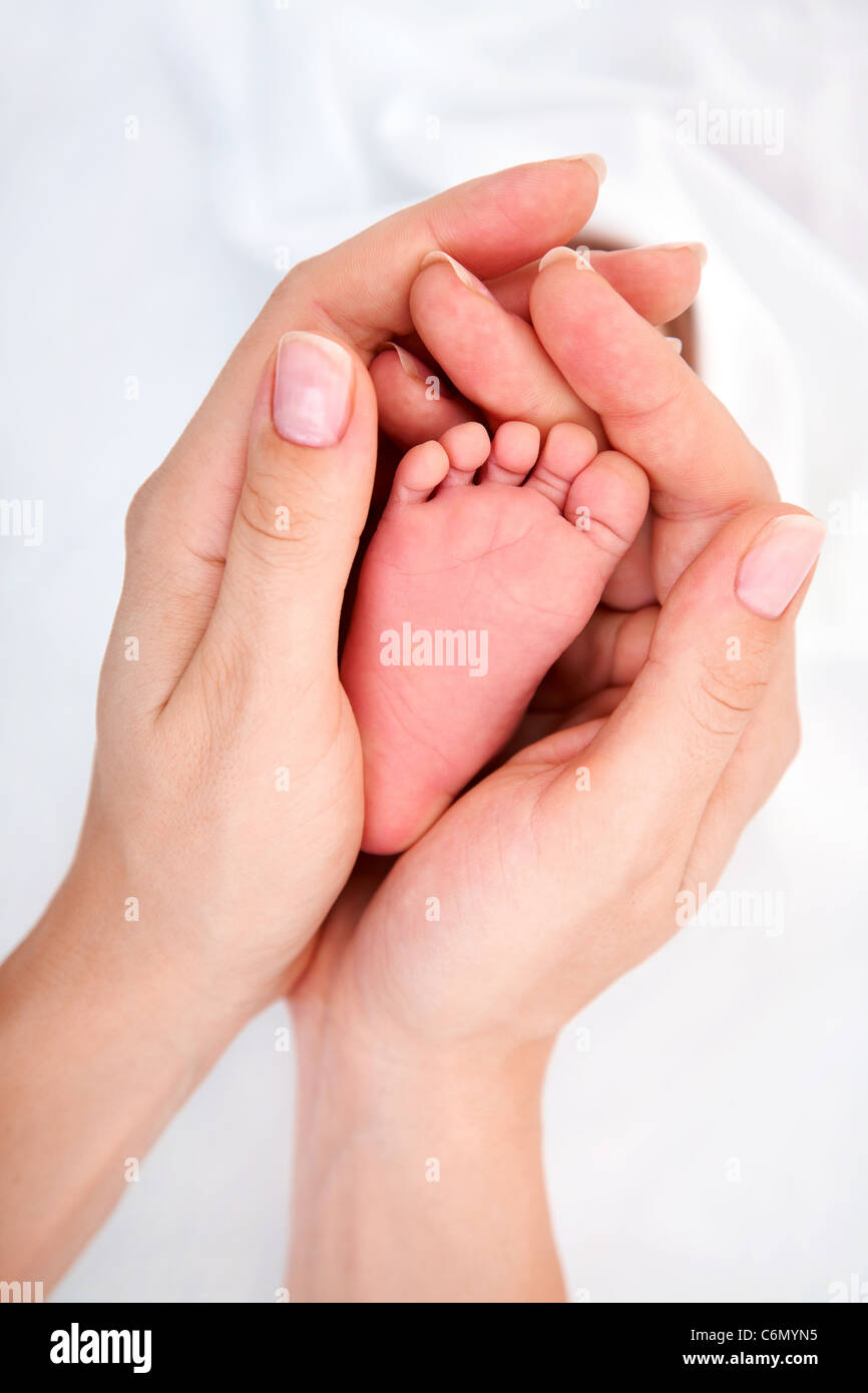 Clouse-Up von neugeborenen Babys Fuß in Mama Hände Stockfoto