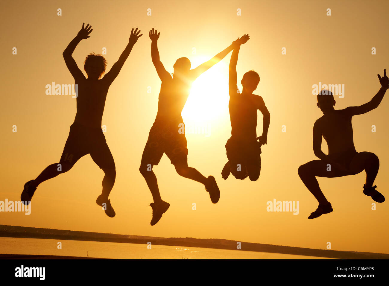 glückliche Jugendliche tanzen am Strand auf schönen Sommer Sonnenuntergang Stockfoto