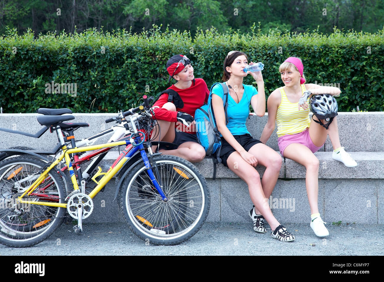 Junge hübsche Frauen, ruhen Sie sich nach Radrennen in den grünen park Stockfoto