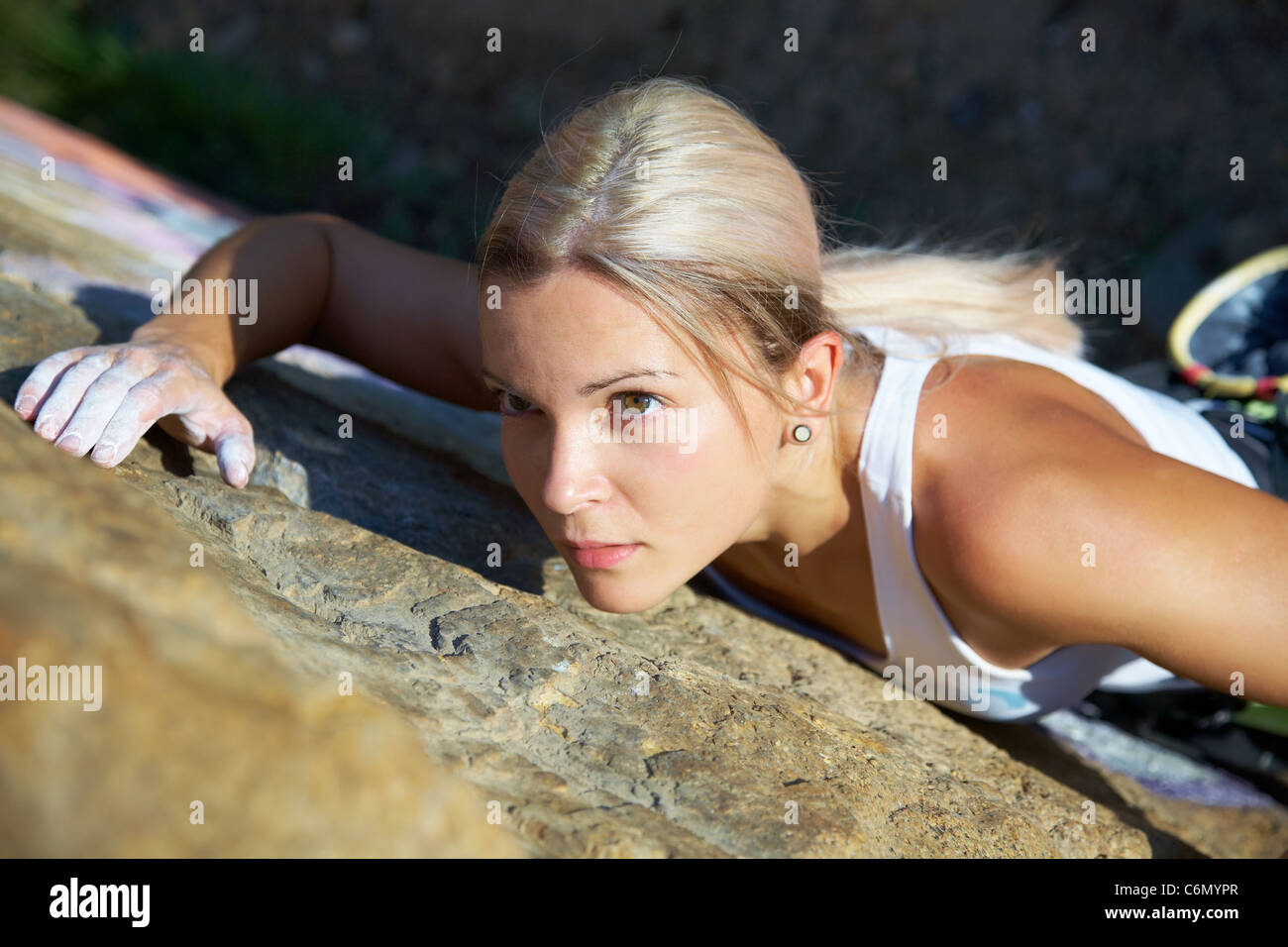Blonde Mädchen Klettern auf den Felsen im Hintergrund Stockfoto