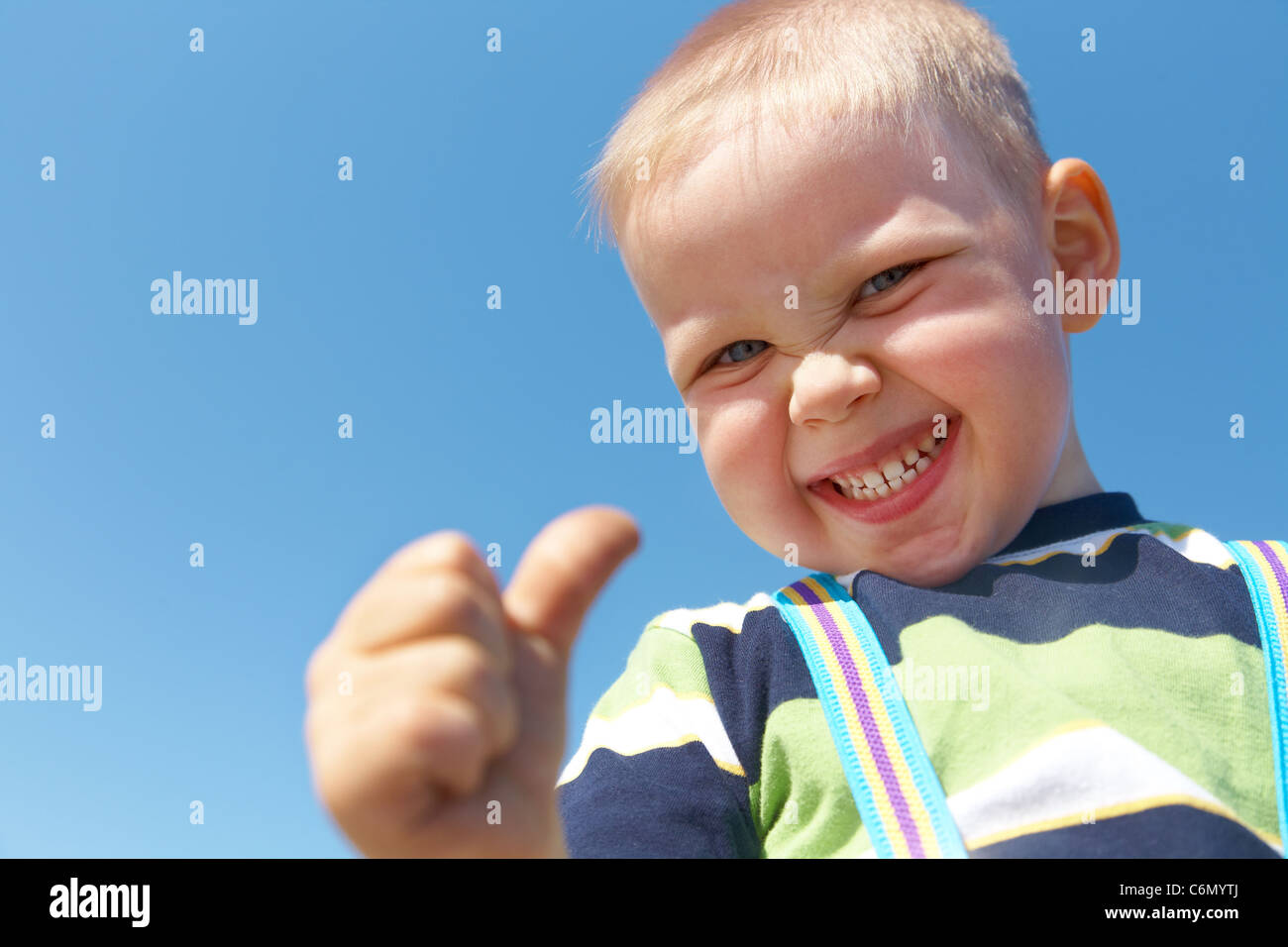 Porträt von glücklich fröhliche kleine Junge gestikulieren Daumen Erfolg Schild Stockfoto