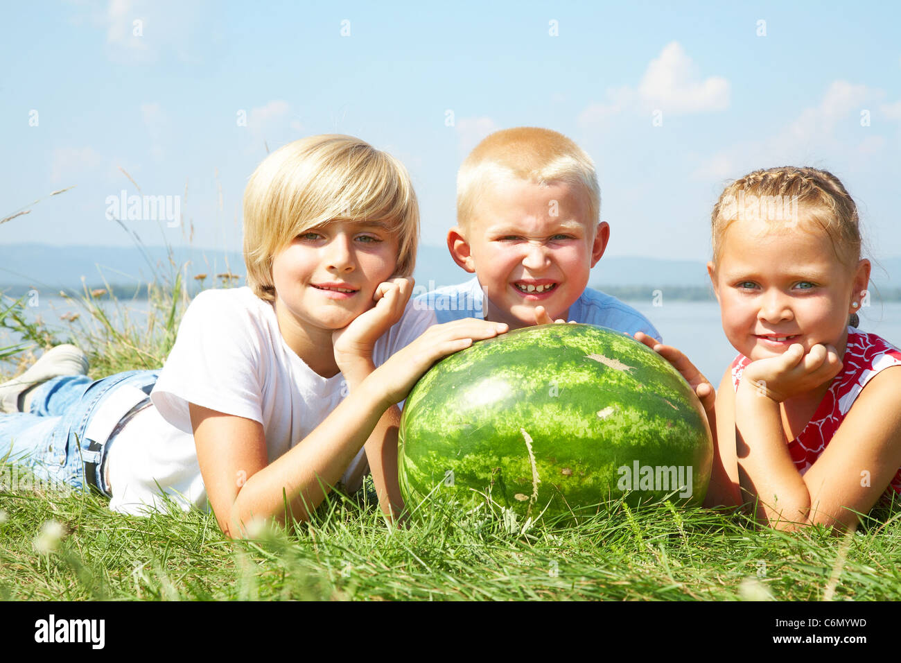Kinder liegen im Rasen mit rote Wassermelone Stockfoto