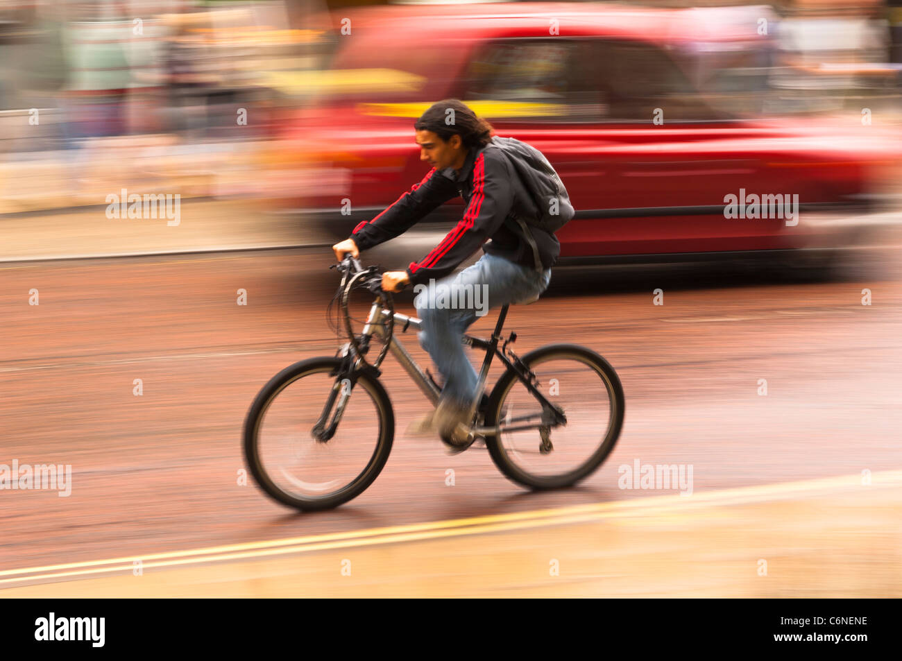 Ein Mann, Radtouren durch die Stadt und bewusste Bewegung zeigt Bewegungsunschärfe in Norwich, Norfolk, England, Großbritannien, Uk Stockfoto