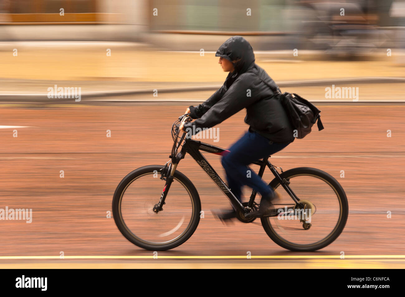 Eine Fahrradtour durch die Stadt und bewusste Bewegung zeigt Frau Bewegungsunschärfe in Norwich, Norfolk, England, Großbritannien, Uk Stockfoto