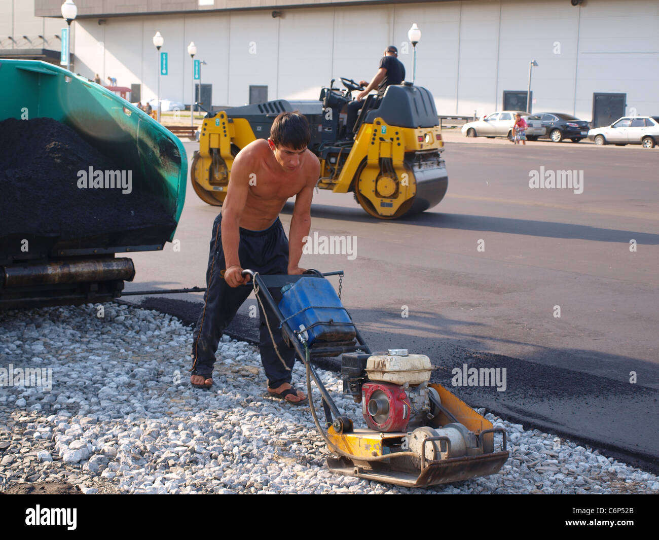 Straße Reparatur Arbeiter mit Gas-Engine powered vibrierenden Müllpresse Stockfoto