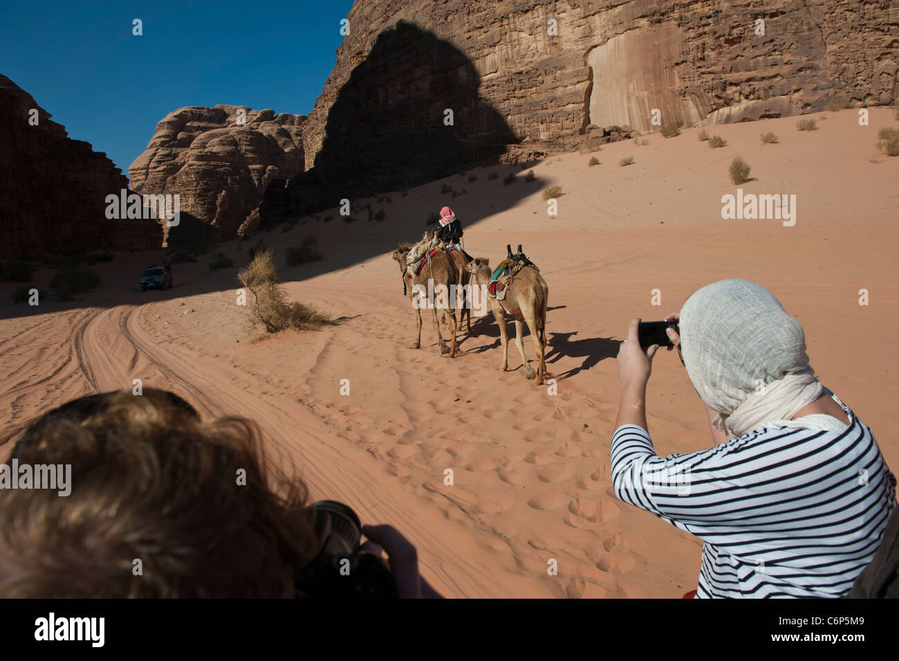 4x4 Jeep Safari vorbei an einem Beduinen camel rider Wadi Rum Jordanien Stockfoto