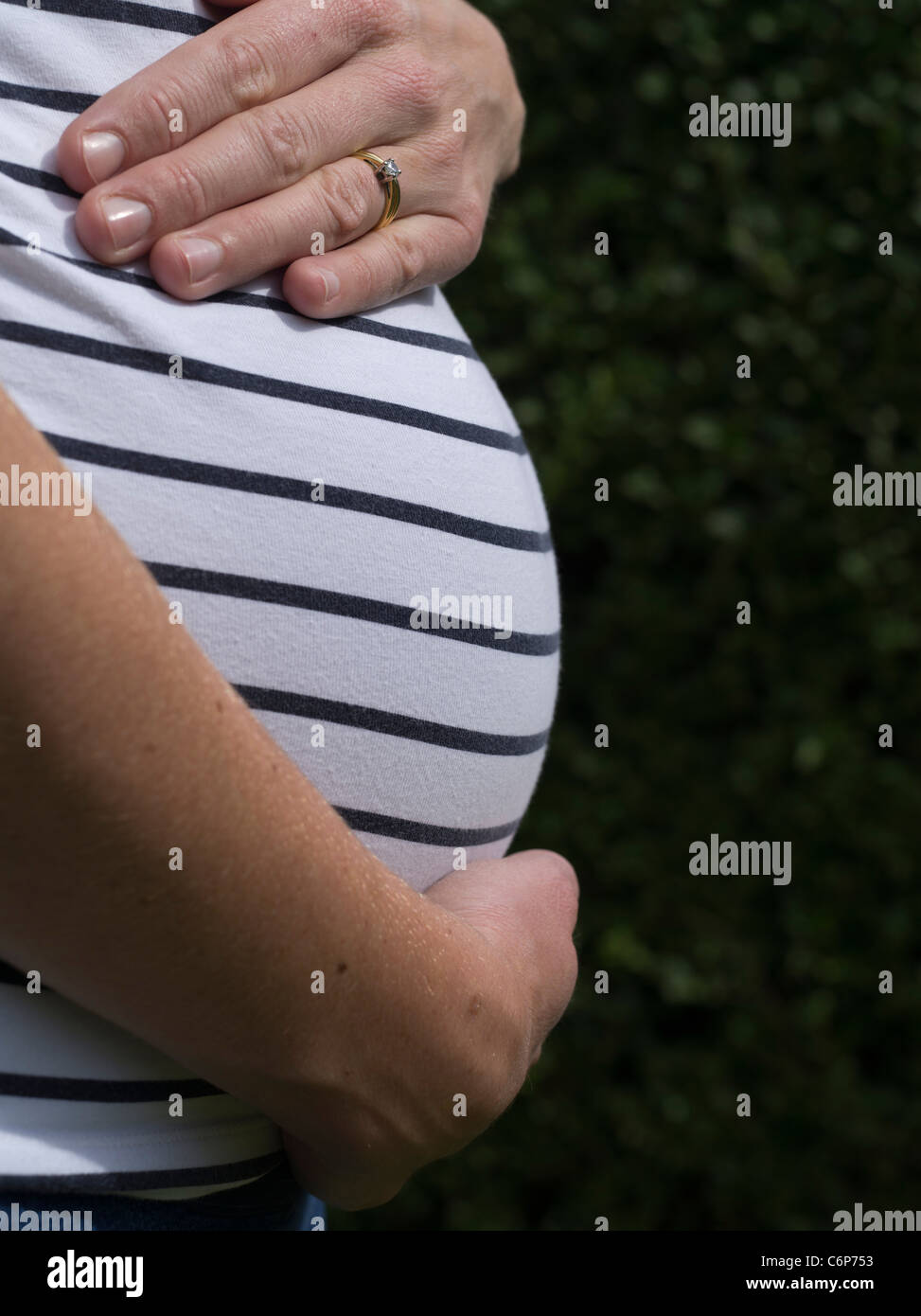 dh Mothers Schwangerschaft Magen FAMILIE UK Schwangere Bauch Frau Beule Mutter Erwachsenen Profil Bauch aus der Seitenansicht Hand Stockfoto