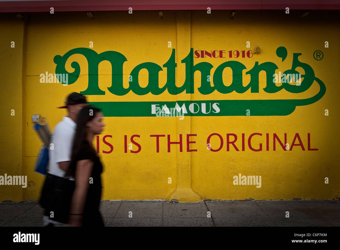 Ein Mann und eine Frau Fuß durch ein Nathan berühmte Werbung Wandbild auf Coney Island im New Yorker Stadtbezirk Brooklyn Stockfoto