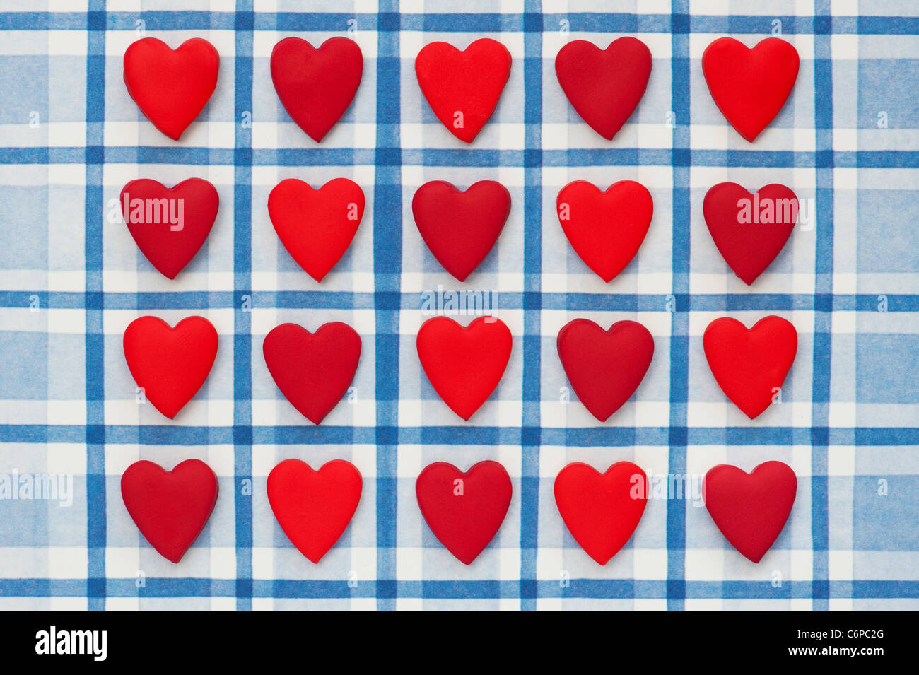 Rot gefärbt Liebe Herzen auf blau karierten Hintergrund Stockfoto