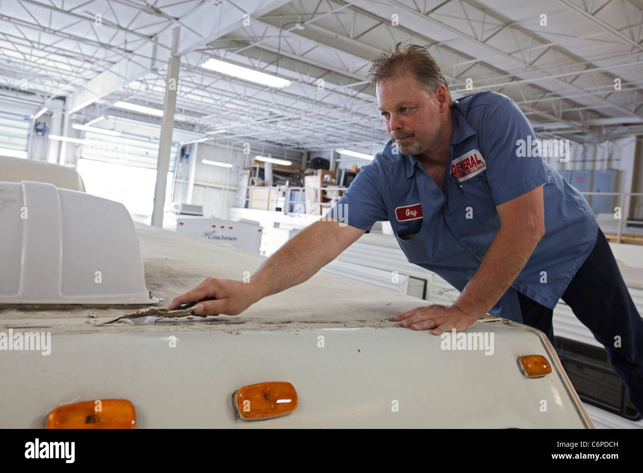 Wixom, Michigan - ein Arbeiter im Shop bei einem Wohnmobil Händler repariert einen RV, die geleckt hatte. Stockfoto