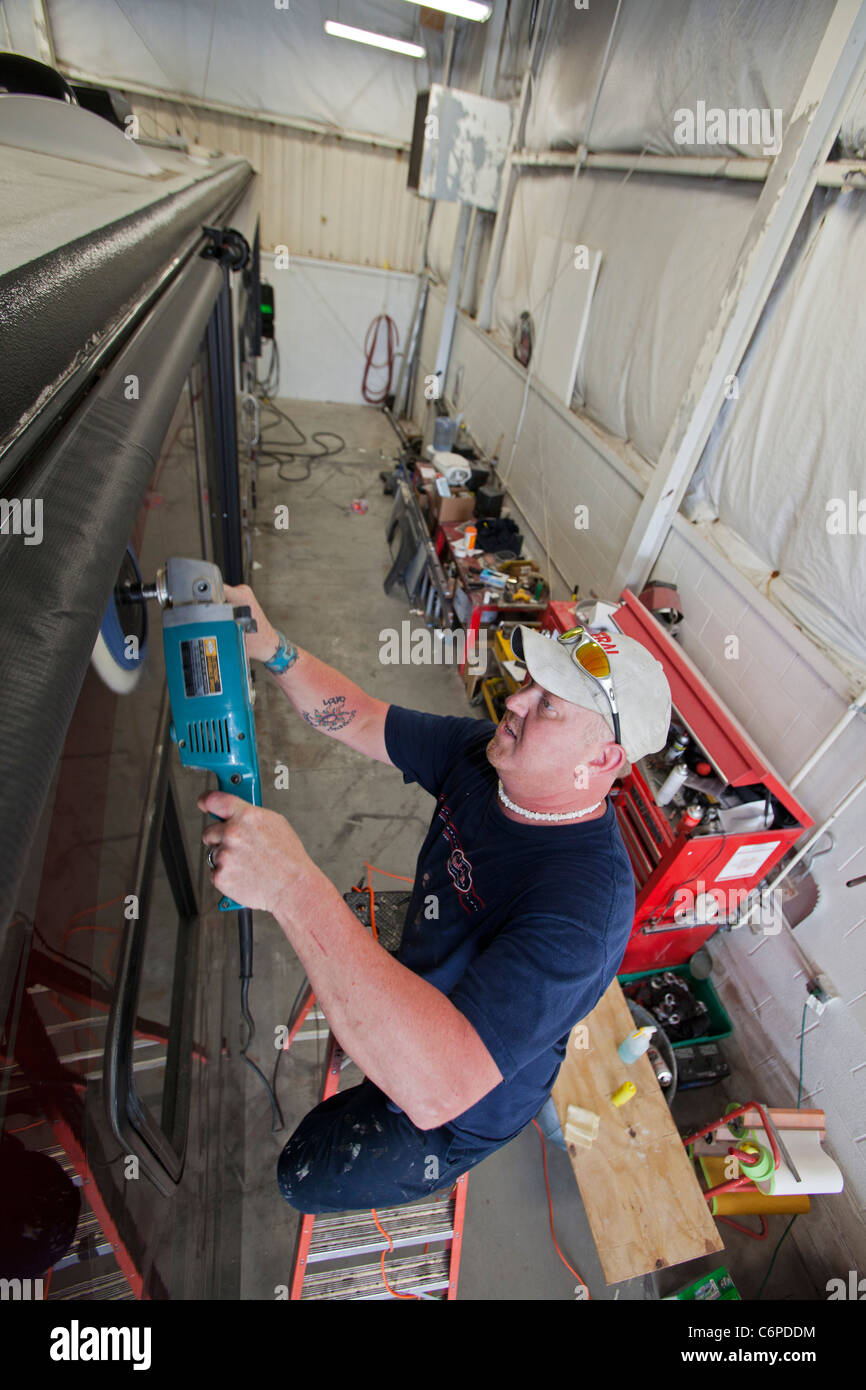 Wixom, Michigan - ein Arbeiter Polituren ein Wohnmobil im Shop bei einem Freizeitfahrzeug-Händler. Stockfoto