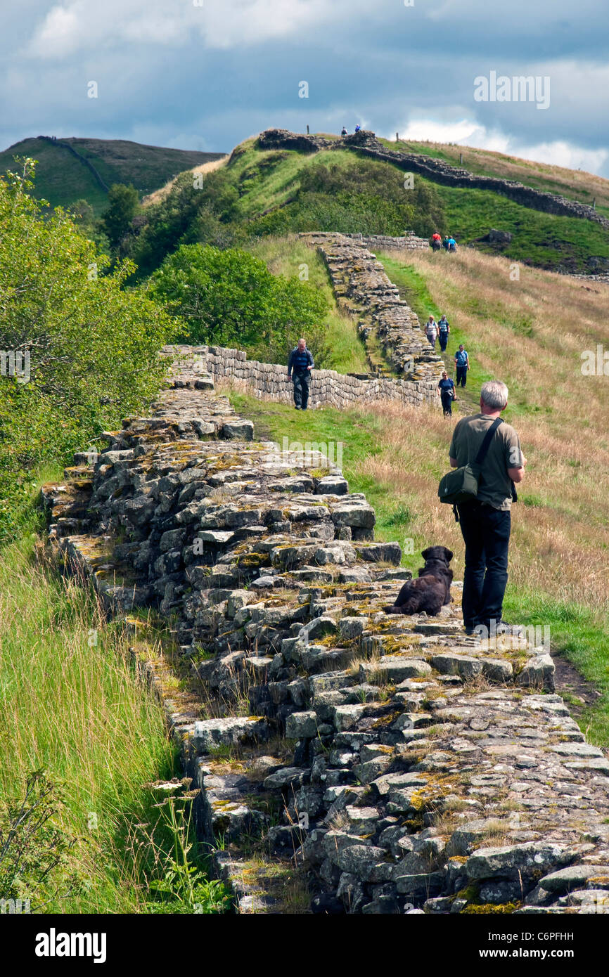 Dramatische Whin Sill Crag Abschnitt der Hadrianswall bei Cawfields im Northumberland National Park mit Wanderer auf nationalen Walking Stockfoto