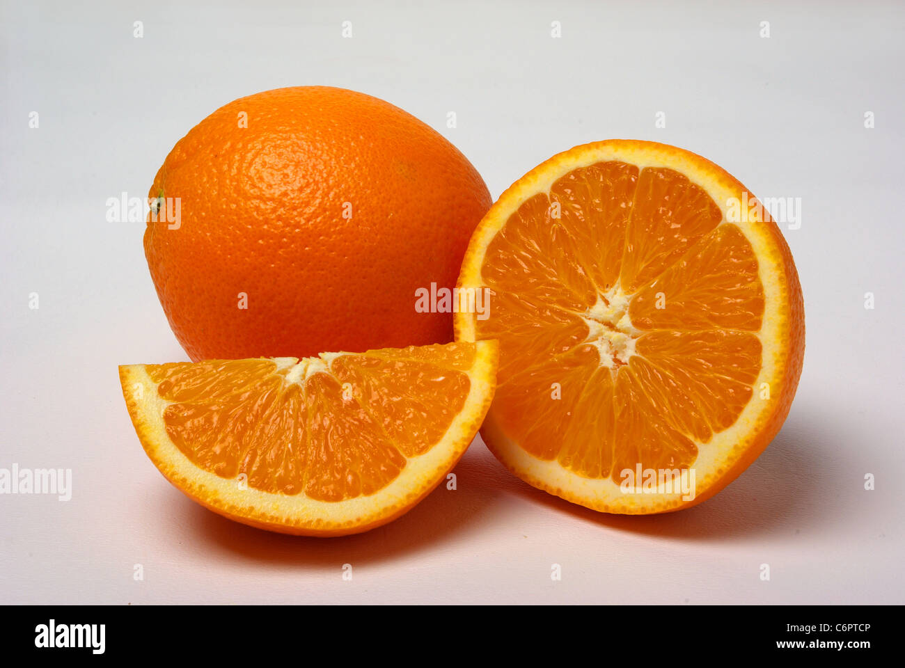 Orange und Scheiben Orangen sitzen auf einem weißen Hintergrund. Stockfoto