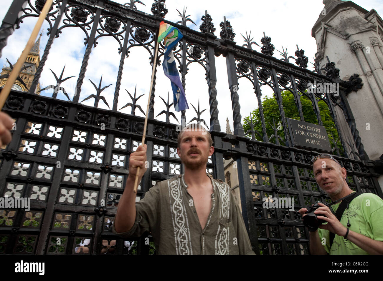 Demokratie-Dorf Camper Simon Moore ist bei den Houses of Parliament, einen Frieden Flagge hängen. Stockfoto
