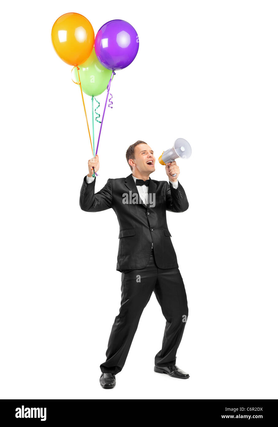 In voller Länge Portrait eines Mannes schreien ein Megaphon zu werfen und Ballons halten Stockfoto