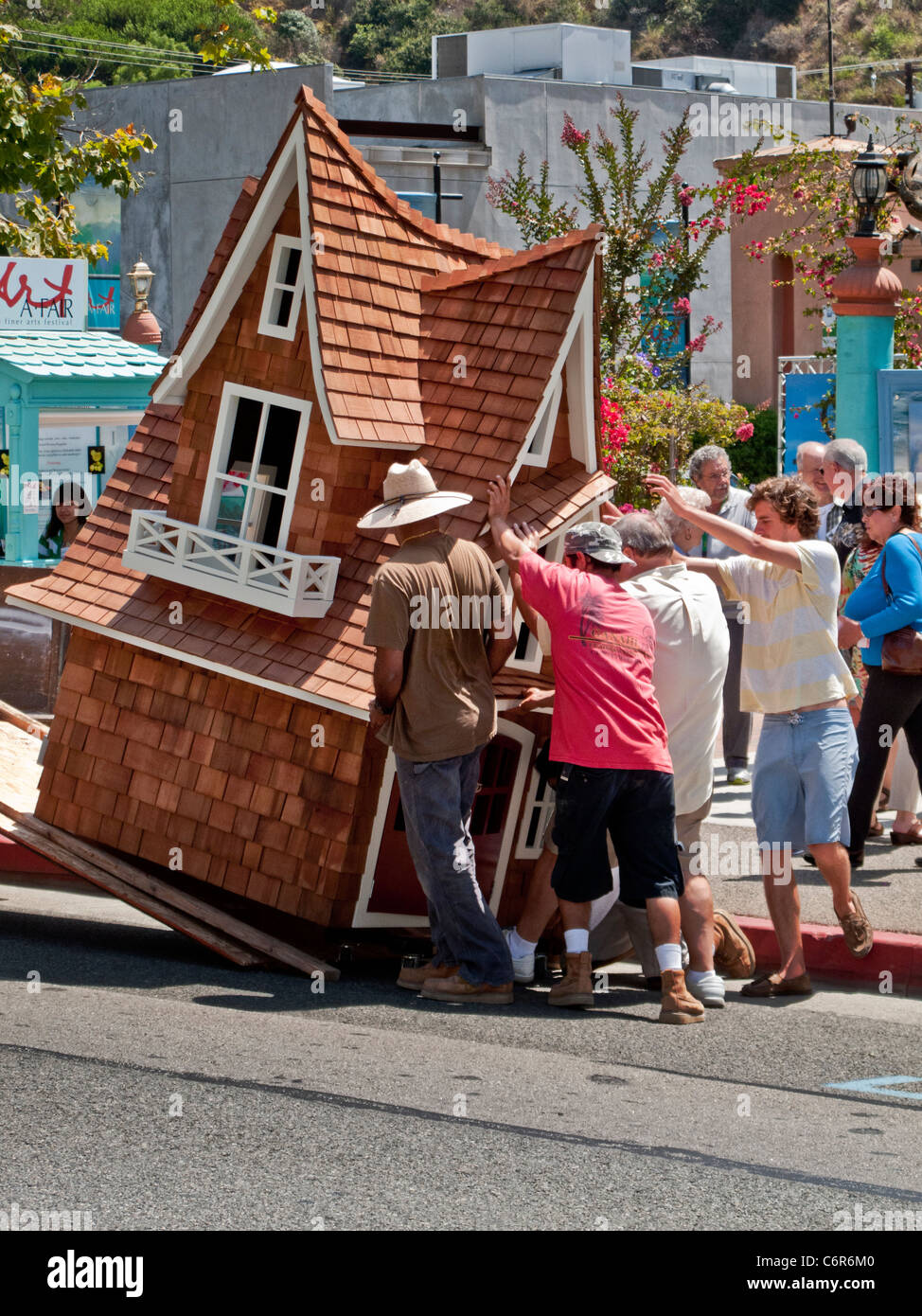 Arbeiter entladen eine phantasievolle Hundehütte aus einem LKW außerhalb eine Kunstausstellung in Laguna Beach, Kalifornien. Stockfoto