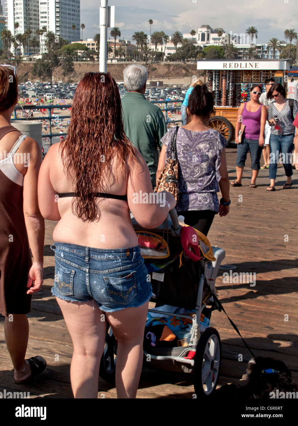 Klar komfortabel und nicht peinlich, eine übergewichtige Frau in einem  Bikini-Oberteil schiebt einen Kinderwagen am Santa Monica Pier  Stockfotografie - Alamy