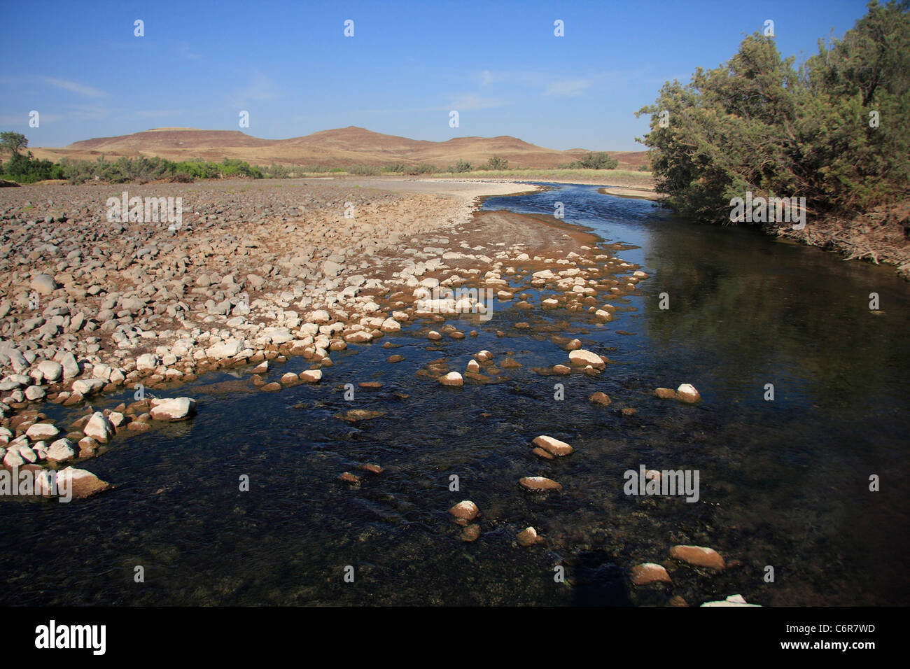 Fluss fließt über die Felsen in Wüstenlandschaft Stockfoto