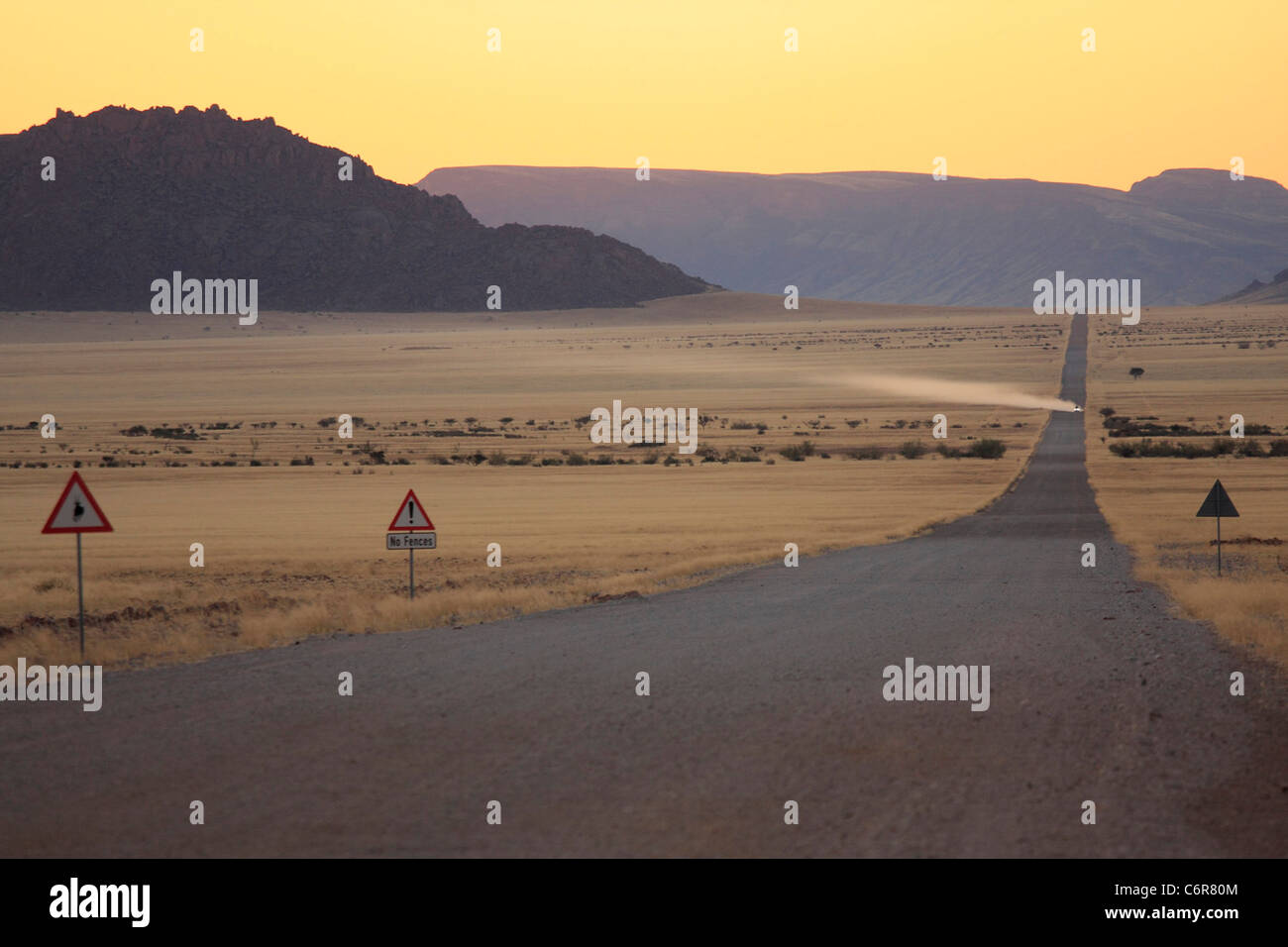 Wüstenlandschaft in der Abenddämmerung mit Staub weg vom Fahrzeug Stockfoto