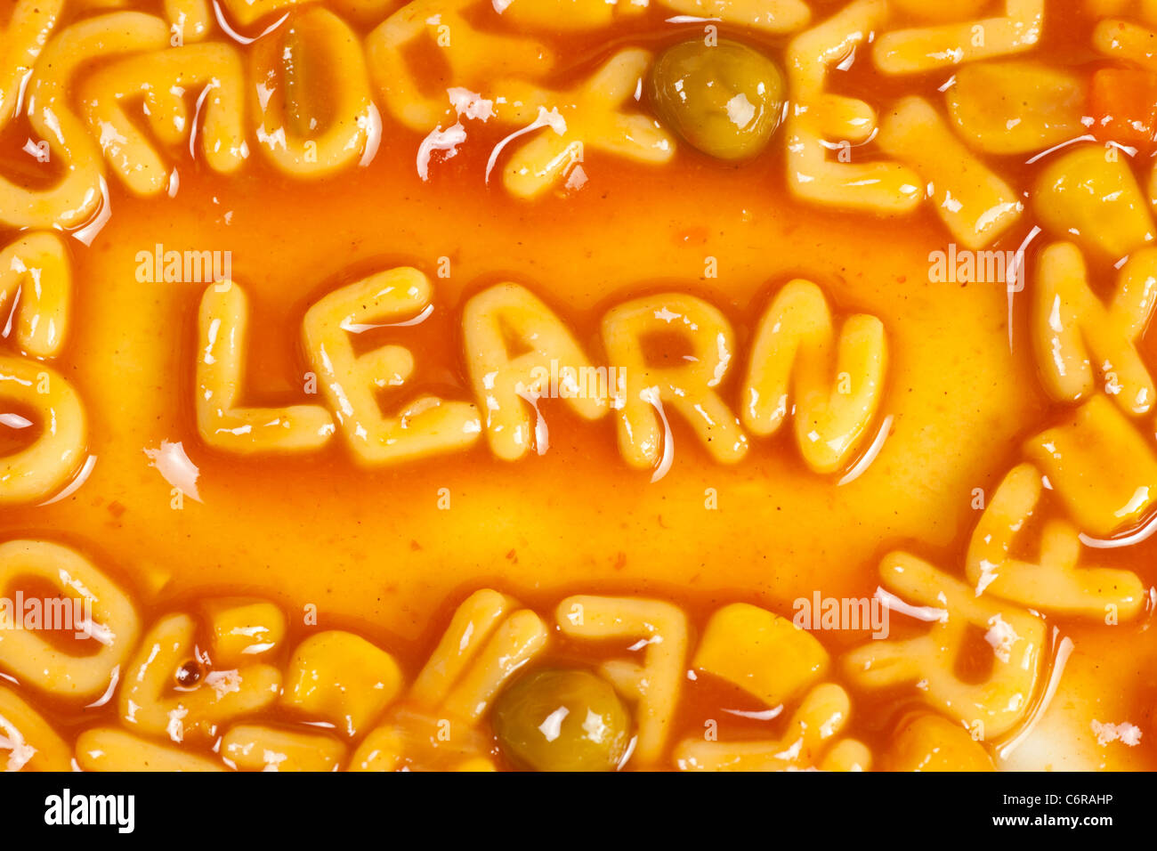 Alphabet geformten Nudeln bilden das Wort lernen in Tomatensauce Stockfoto