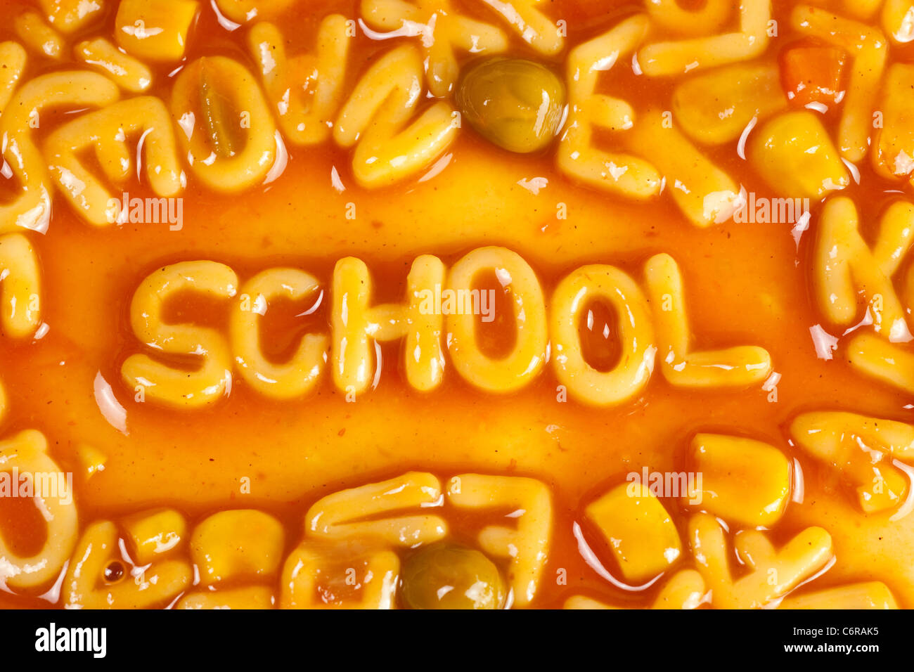 Alphabet geformten Nudeln bilden das Wort Schule in Tomatensauce Stockfoto