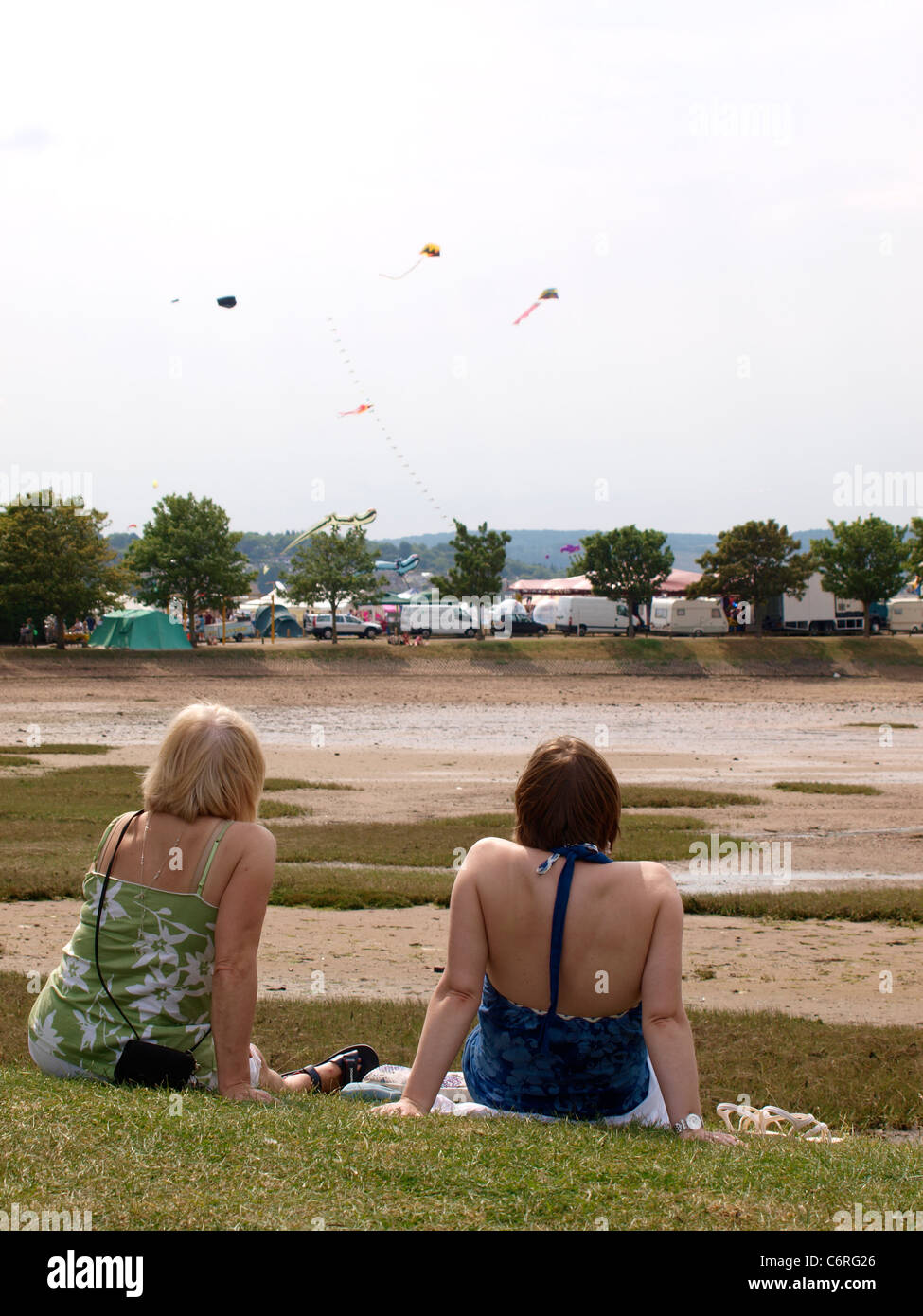 Zwei Frauen saßen zusammen beobachten Drachenfestival, UK Stockfoto