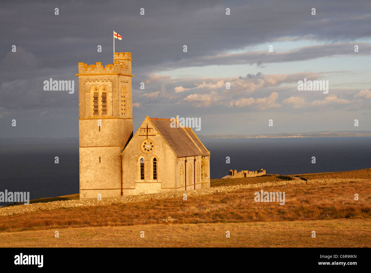 St. Helenas Kirche im Abendlicht mit der Burg in der Ferne auf Lundy Island, Devon, England, UK im August - St Helens Kirche Stockfoto