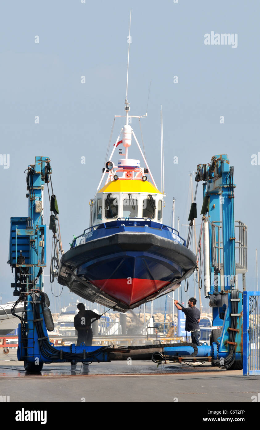 Boot, Reinigung, Männer reinigen Sie die Unterseite eines Bootes aus dem Wasser, UK Stockfoto