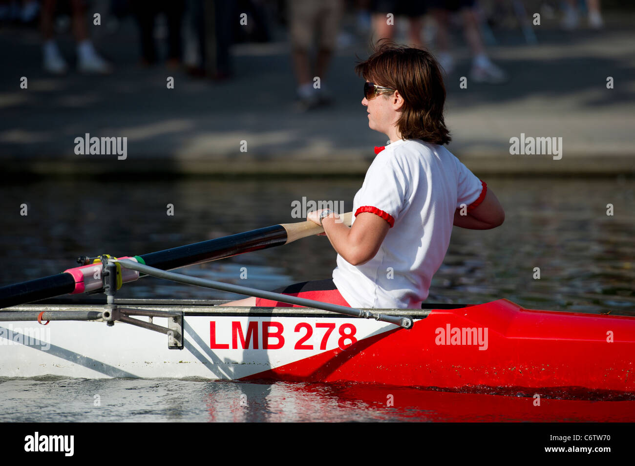 Schließen Sie herauf Bild eines Mitglieds der alle weiblichen Besatzung von acht im Ruderboot auf dem Fluss Cam, Cambridge an einem Sommerabend. Stockfoto