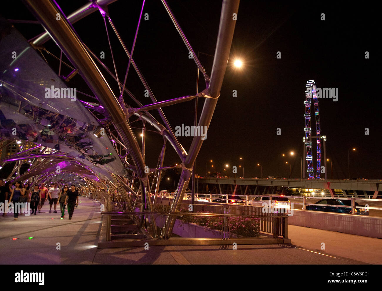 Menschen zu Fuß entlang der modernen Helix-Brücke mit dem Singapore Flyer im Hintergrund, die Marina, Singapur Asien Stockfoto