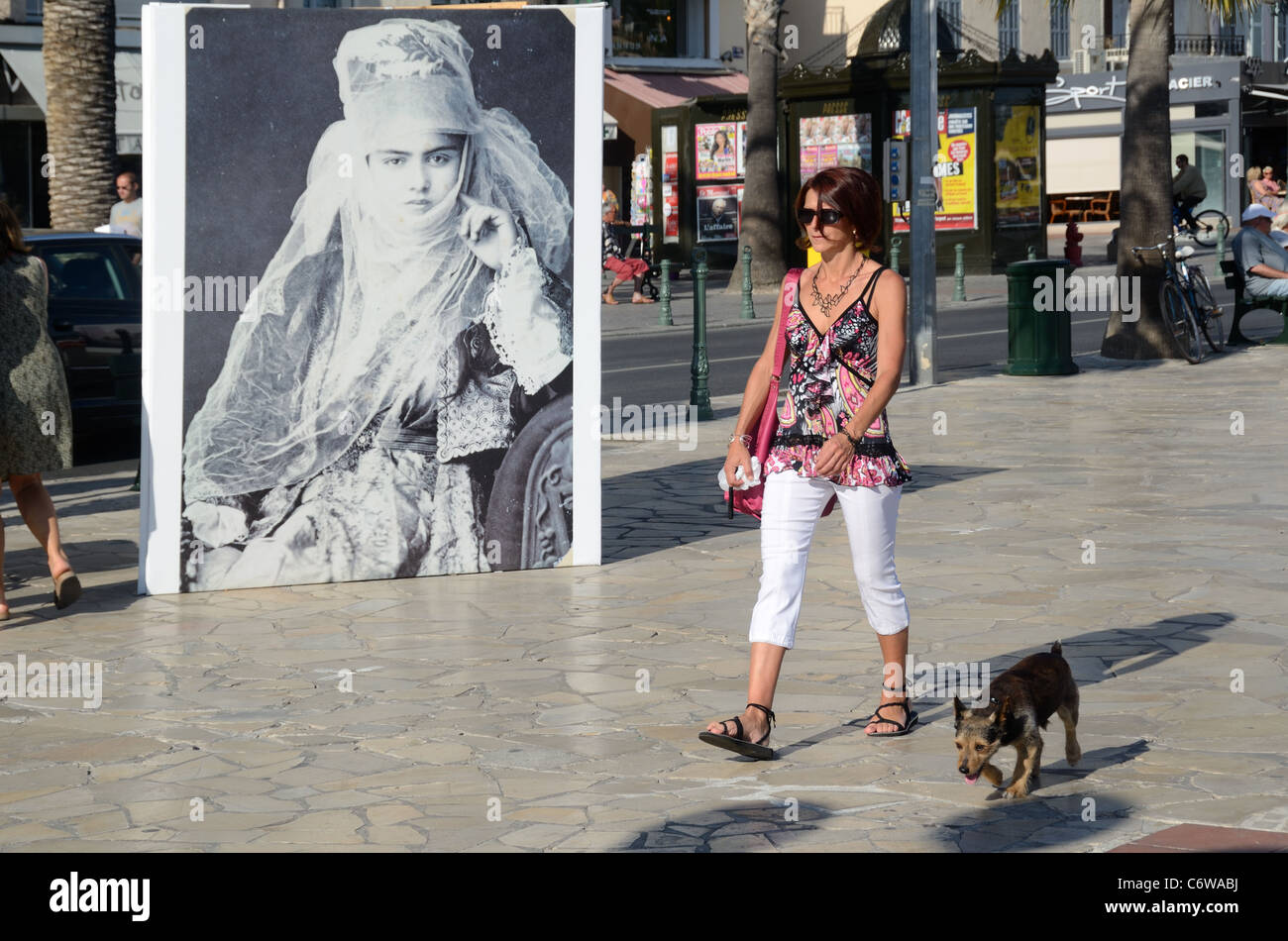 Frau Wanderhund mit Foto einer verschleierten türkischen Frau in den Backgrouns, Sanary-sur-Mer, Var, Provence, Frankreich Stockfoto